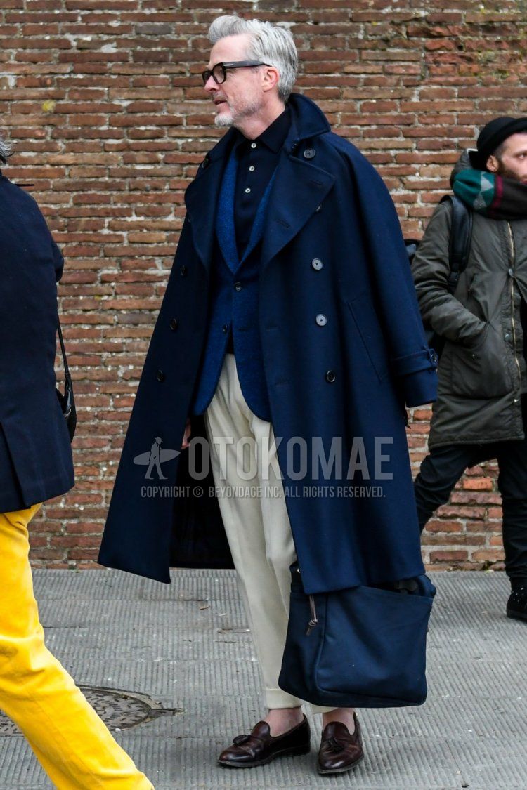 Men's coordinate and outfit with plain glasses, plain navy Ulster coat, plain blue tailored jacket, plain navy polo shirt, plain white slacks, and brown tassel loafer leather shoes.
