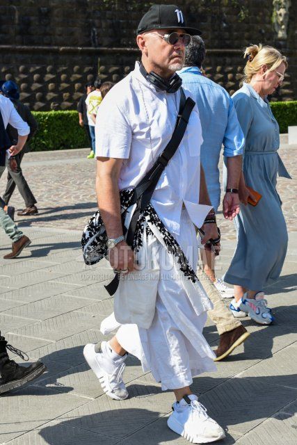 Men's coordinate and outfit with plain black baseball cap, plain silver sunglasses, plain white shirt, plain white cropped pants, plain white Adidas socks, and white low-cut sneakers.