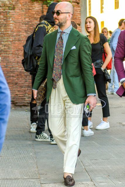 Men's coordinate and outfit with plain sunglasses, plain green tailored jacket, white striped shirt, plain white wide-leg pants, and brown tassel loafer leather shoes.
