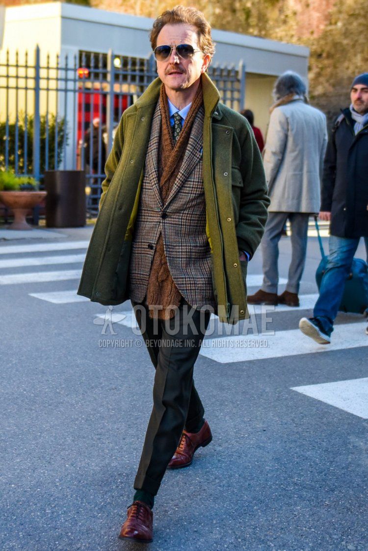 Solid silver sunglasses, solid brown scarf/stall, solid olive green M-65, blue striped shirt, brown checked tailored jacket, solid gray slacks, solid green socks, brown wingtip leather shoes, gray komon tie. Men's coordinate and outfit.