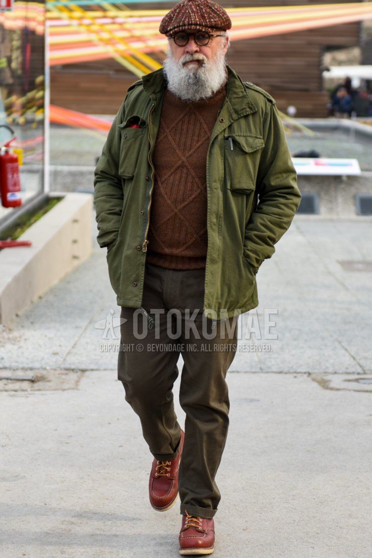 Men's fall/winter outfit with brown hunting cap, plain black glasses, plain olive green M-65, plain brown turtleneck knit, plain olive green chinos, and brown boots.