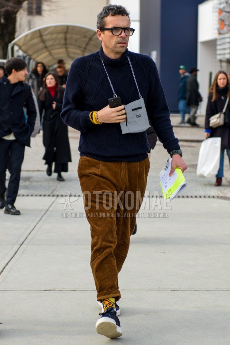 Men's fall/winter coordinate and outfit with plain black glasses, plain navy turtleneck knit, plain brown winter pants (corduroy,velour), multi-colored socks socks, navy low-cut sneakers.