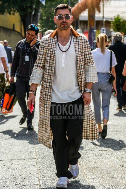 Men's spring and fall coordinate and outfit with plain white sunglasses, plain beige/multi-colored tailored jacket, plain white T-shirt with henley neck, plain black wide pants, and white low-cut sneakers.