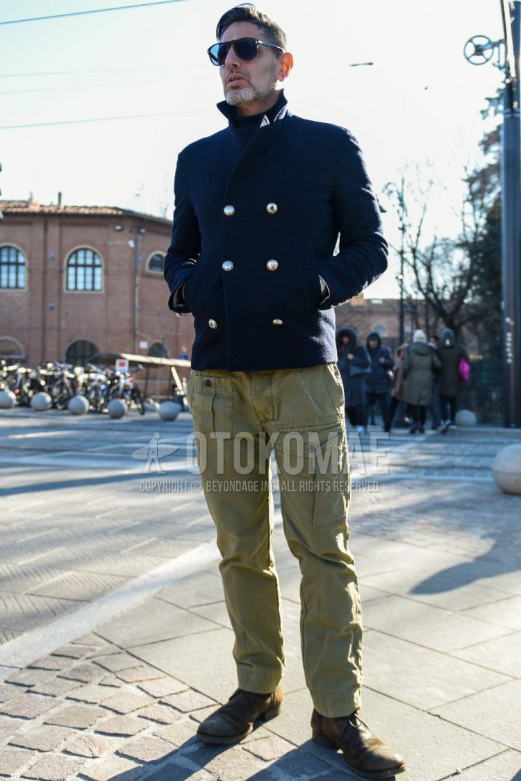 Men's fall/winter outfit with plain black sunglasses, plain navy P-coat, plain olive green cargo pants, plain olive green ankle pants, plain olive green chinos, and brown boots.