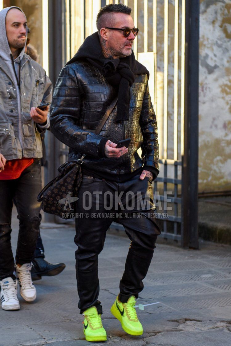 Men's fall/winter outfit and outfit with plain black sunglasses, plain black leather jacket (not rider), plain black leather bottoms, Nike Off White Zaten Air Force 1 yellow low-cut sneakers, and black bag shoulder bag.