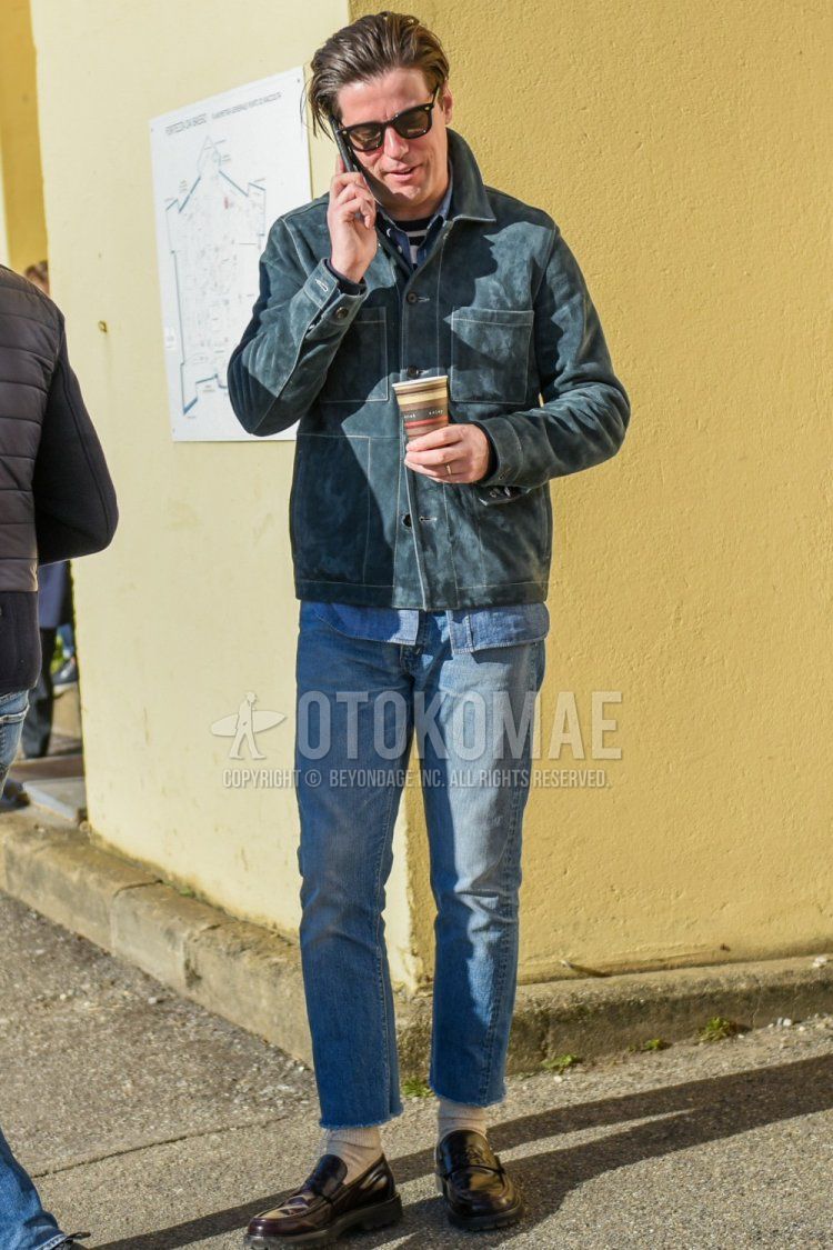Wellington solid black sunglasses, solid gray leather jacket (not riders), solid blue denim/chambray shirt, white and black striped T-shirt, solid light blue denim/jeans, solid light blue cropped pants, solid beige socks, brown coin loafer leather shoes with a men's fall/winter outfit/coordination.
