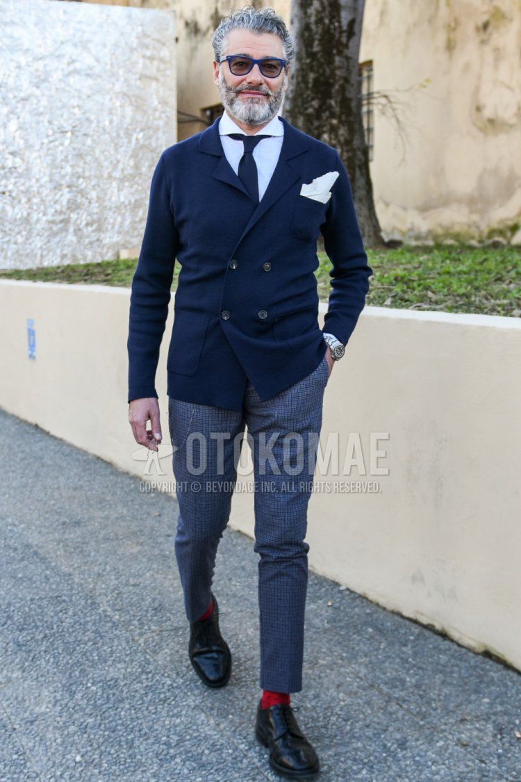 Men's spring and fall outfit with plain blue sunglasses, plain navy tailored jacket, plain white shirt, gray checked slacks, plain red socks, black wingtip leather shoes, and plain dark gray tie.