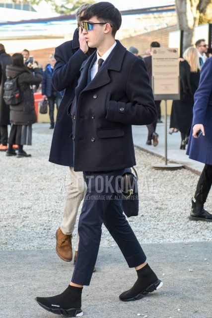 Men's fall/winter coordinate and outfit with plain black sunglasses, plain navy P-coat, plain white shirt, plain gray slacks, plain gray cropped pants, and Balenciaga speed trainers with black high-cut sneakers.