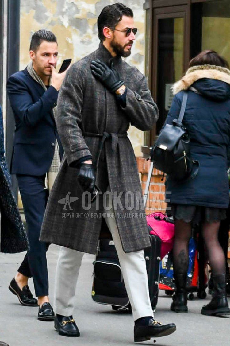 Men's outfit and outfit with teardrop plain black sunglasses, gray checked belted coat, plain white slacks, plain black socks, and Gucci black bit loafer leather shoes.