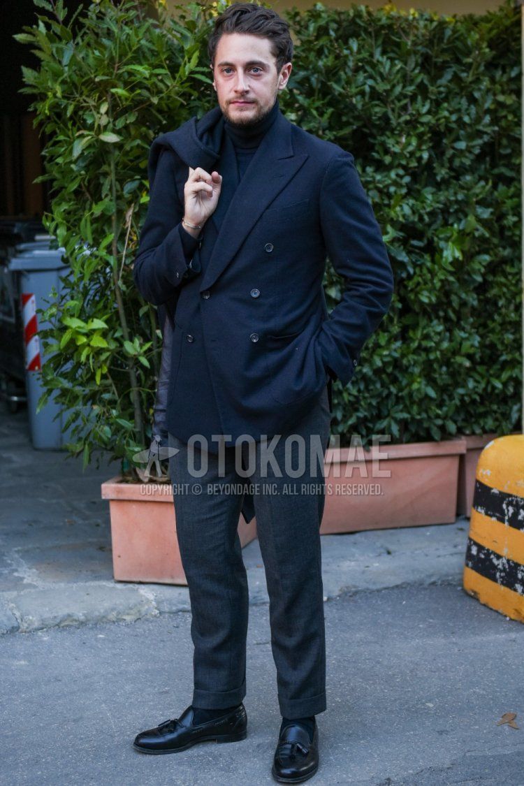 Men's spring and fall outfit with dark gray solid tailored jacket, dark gray solid turtleneck knit, gray solid slacks, gray solid ankle pants, black solid socks, and black tassel loafer leather shoes.