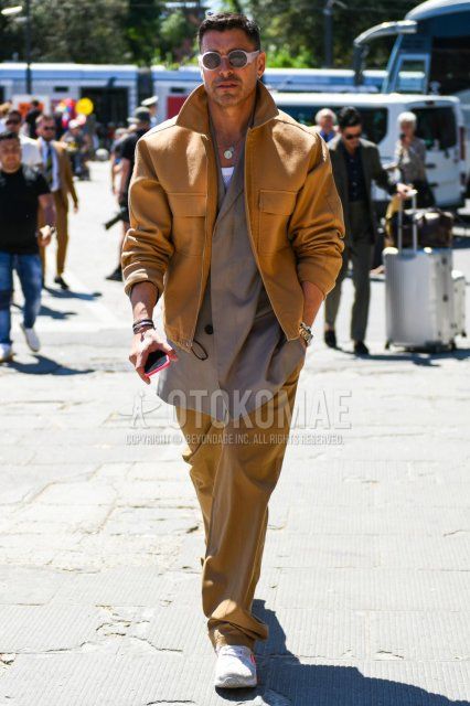 Men's coordinate and outfit with clear and white solid color sunglasses, brown solid color outerwear, beige solid color outerwear, brown solid color wide pants, and white low-cut sneakers.