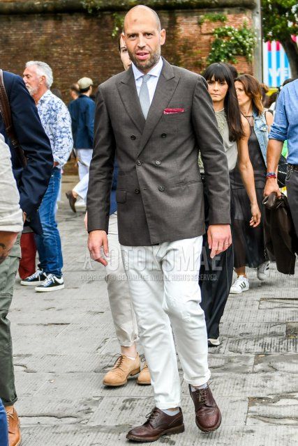 Men's coordination and outfit with plain gray tailored jacket, plain white shirt, plain white denim/jeans, brown wingtip leather shoes, and plain gray tie.