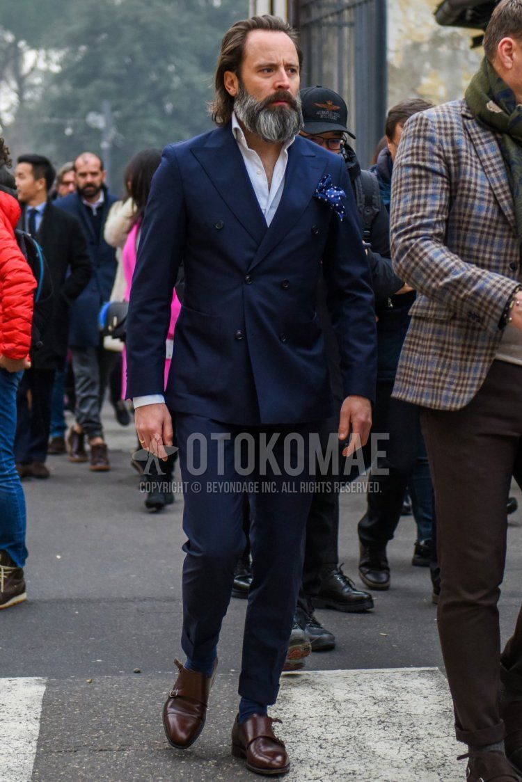Men's coordinate and outfit with plain white shirt, plain navy socks, brown monk shoes leather shoes, and plain navy suit.
