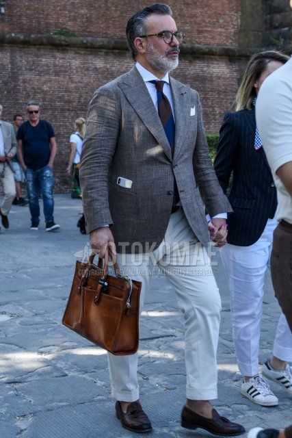 Men's coordinate and outfit with black tortoiseshell glasses, plain gray tailored jacket, plain white shirt, plain white cotton pants, brown tassel loafer leather shoes, plain brown briefcase/handbag, brown navy regimental tie.