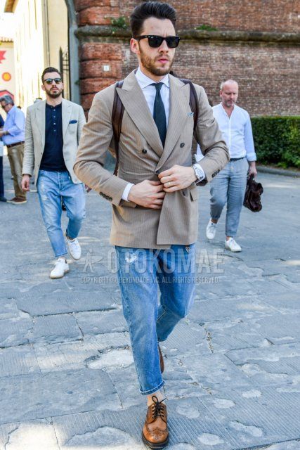 Men's coordinate and outfit with plain black Wellington sunglasses, plain brown tailored jacket, plain white shirt, plain blue denim/jeans, plain blue denim/jeans, brown brogue shoes leather shoes and plain black tie.