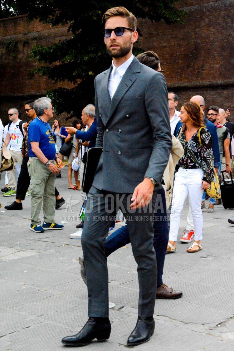 Men's coordinate and outfit with plain black sunglasses, plain white shirt, black boots, plain black clutch bag/second bag/drawstring, and plain gray suit.