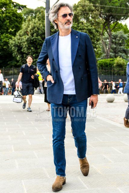 Men's coordinate and outfit with plain sunglasses, plain navy tailored jacket, plain white t-shirt, plain blue denim/jeans, and beige side gore boots.