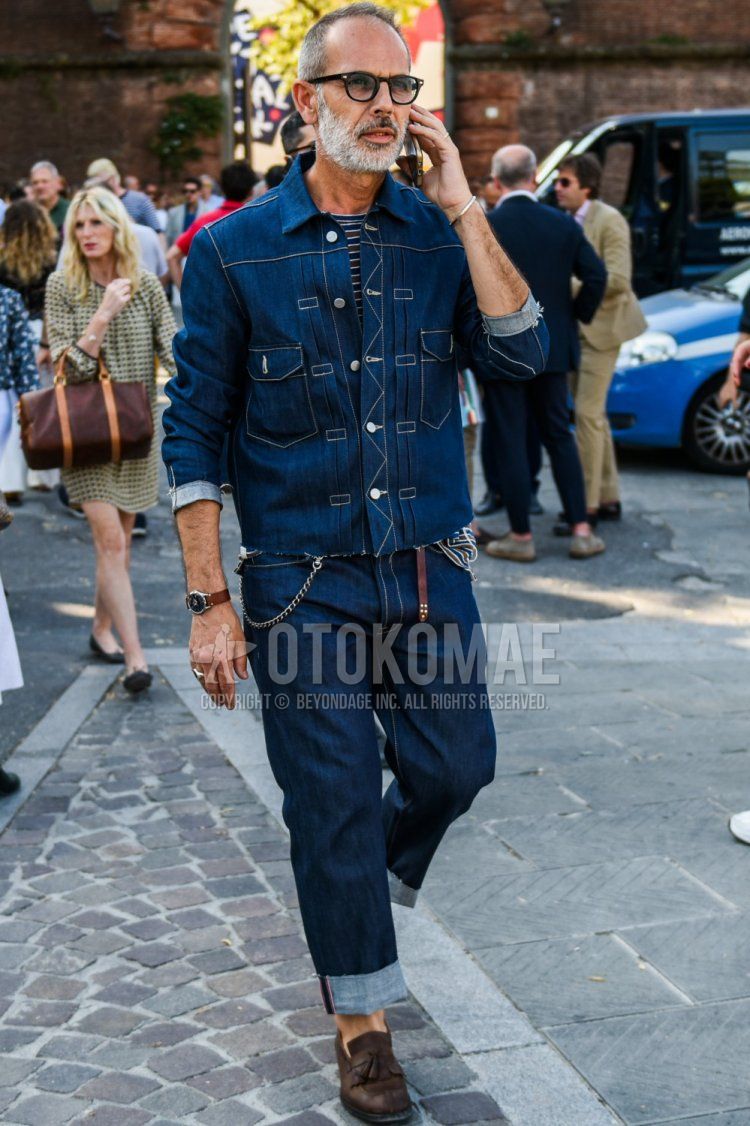 Men's coordinate and outfit with plain black glasses, plain navy denim jacket, navy striped t-shirt, plain navy denim/jeans, and brown tassel loafer leather shoes.