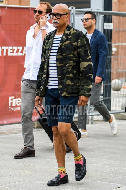 Men's coordinate and outfit with plain glasses, multi-colored camouflage tailored jacket, white striped t-shirt, plain navy shorts, multi-colored socks socks, and black coin loafer leather shoes.