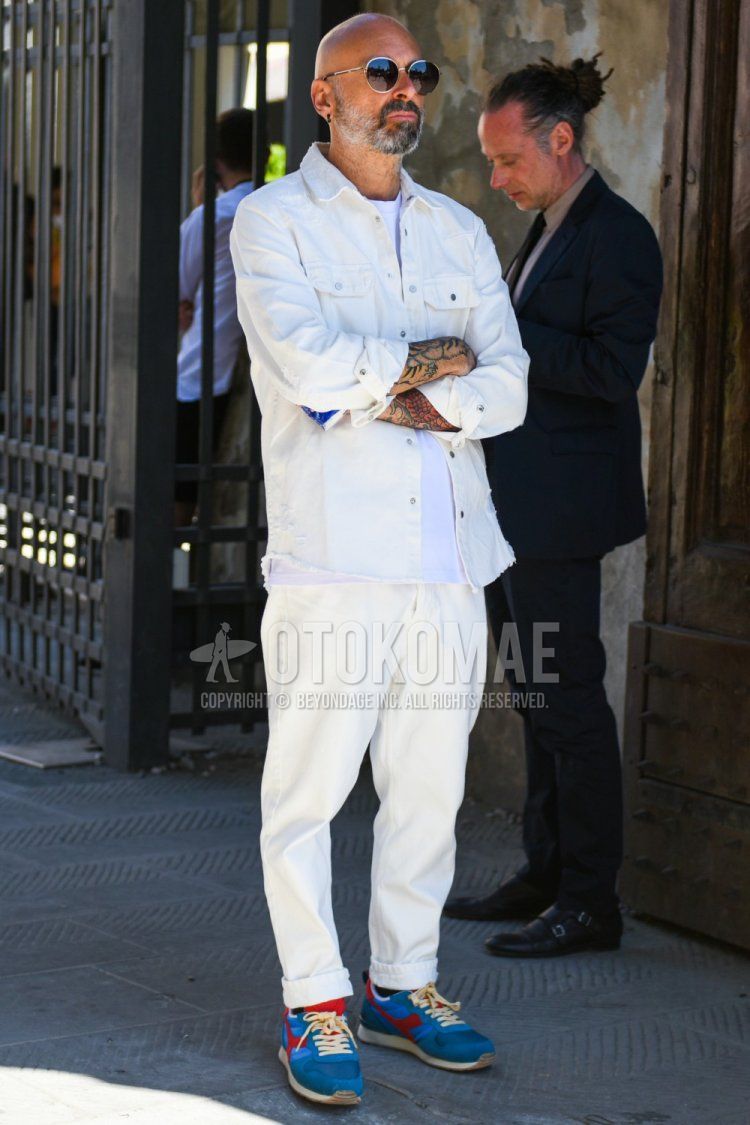 Men's coordinate and outfit with plain silver/black sunglasses, plain white denim/chambray shirt, plain white t-shirt, plain white cotton pants, and Diadora multi-colored low-cut sneakers.