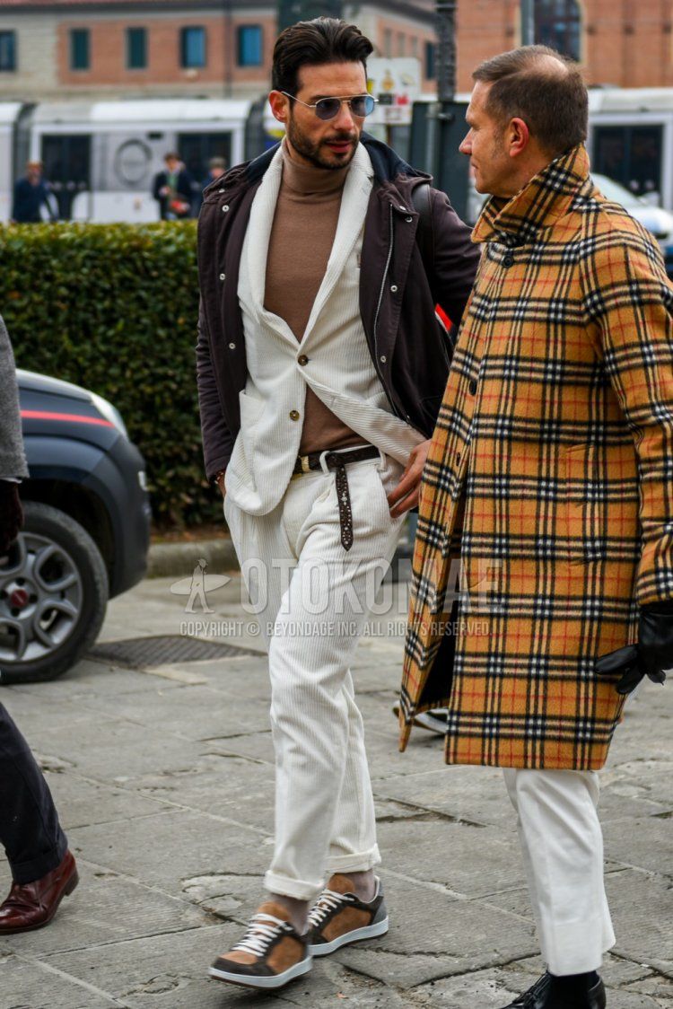 Men's fall/winter outfit with plain silver sunglasses, plain brown hooded coat, plain beige sweater, plain brown leather belt, plain gray socks, brown/beige low-cut sneakers, and plain white suit.