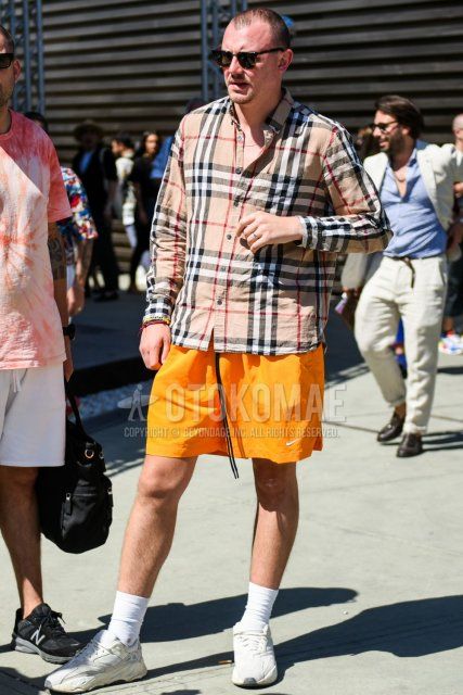 Men's summer coordinate and outfit with plain black sunglasses, Burberry beige checked shirt, Nike plain orange shorts, plain white socks, and white low-cut sneakers.