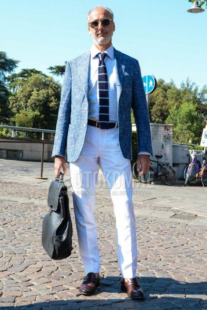 Spring and fall men's coordinate and outfit with beige tortoiseshell sunglasses, blue outer tailored jacket, white checked shirt, plain black leather belt, plain white cotton pants, brown coin loafer leather shoes, plain black backpack, navy striped knit tie.