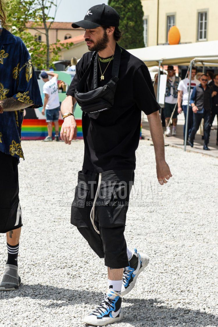 Summer men's coordinate and outfit with black one-pointed baseball cap, plain black t-shirt with mock neck, plain black cargo pants, white one-pointed socks, Nike Sakai Blazer Mid white, light blue and black high-cut sneakers and plain black sackosh.