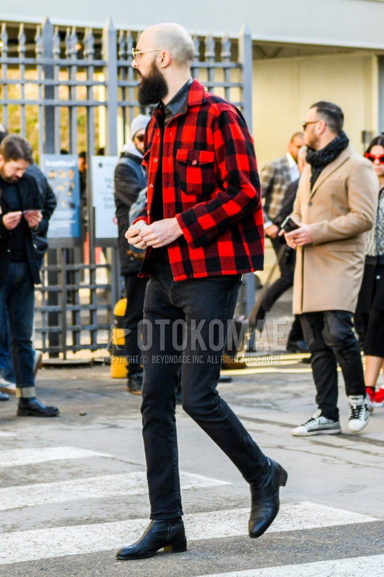 Winter men's coordination and outfit with red checked trucker jacket, plain black shirt, plain black denim/jeans, and black boots.