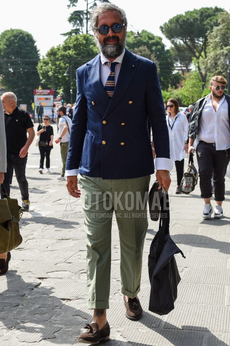 Men's spring/summer/fall outfit with plain black sunglasses from Boston, plain navy tailored jacket, plain white shirt, plain green slacks, brown tassel loafer leather shoes, and navy/red border knit tie.