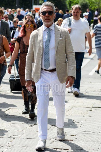 Men's spring and fall outfit and outfit with plain black sunglasses, plain beige tailored jacket, plain white shirt, plain brown leather belt, plain mesh belt, plain white cotton pants, gray low-cut sneakers, and gray necktie tie.