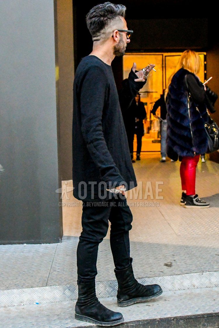 Men's winter coordination and outfit with solid color glasses, solid color black sweater, solid color black denim/jeans, and black boots.