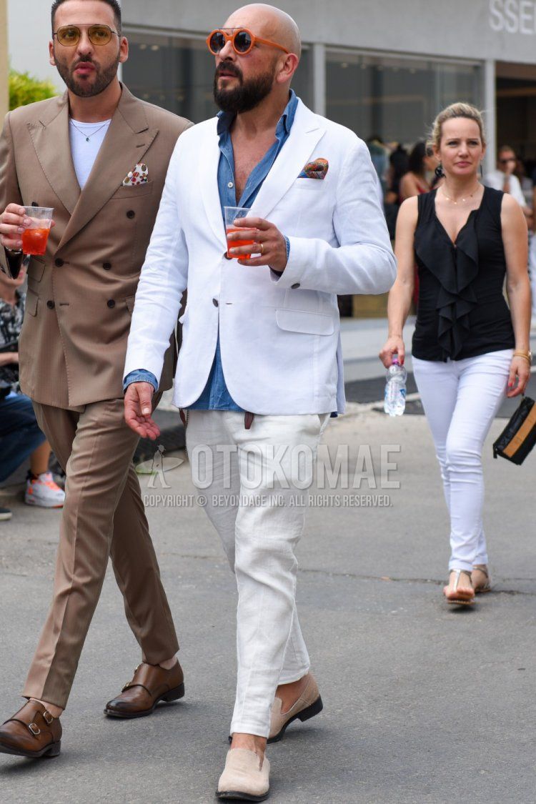 Men's spring/summer/autumn coordination and outfit with plain orange sunglasses, plain white tailored jacket, plain blue denim/chambray shirt, plain white linen ankle pants, and beige moccasins/deck shoes leather shoes.