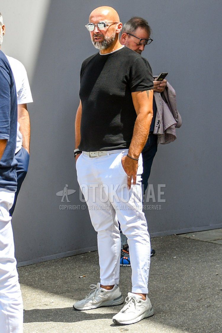 A summer men's coordinate and outfit with plain sunglasses, plain black sweater, plain white t-shirt, plain white leather belt, plain white cotton pants, and white low-cut sneakers.