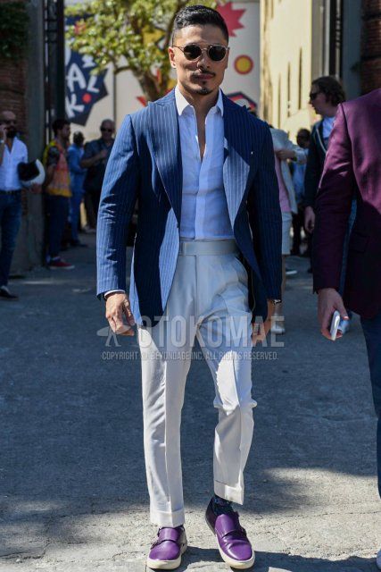 Men's spring, summer, and fall coordinate and outfit with gold and black solid color sunglasses, navy solid color tailored jacket, white solid color shirt, white solid color slacks, multi-color solid color socks, and purple low-cut sneakers.