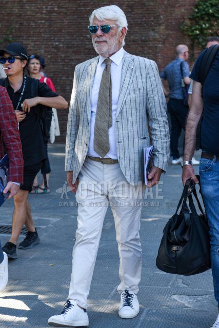 Spring and fall men's coordinate and outfit with clear solid sunglasses, gray striped tailored jacket, solid white shirt, solid gray leather belt, solid white cotton pants, white low-cut sneakers, and solid gray tie.