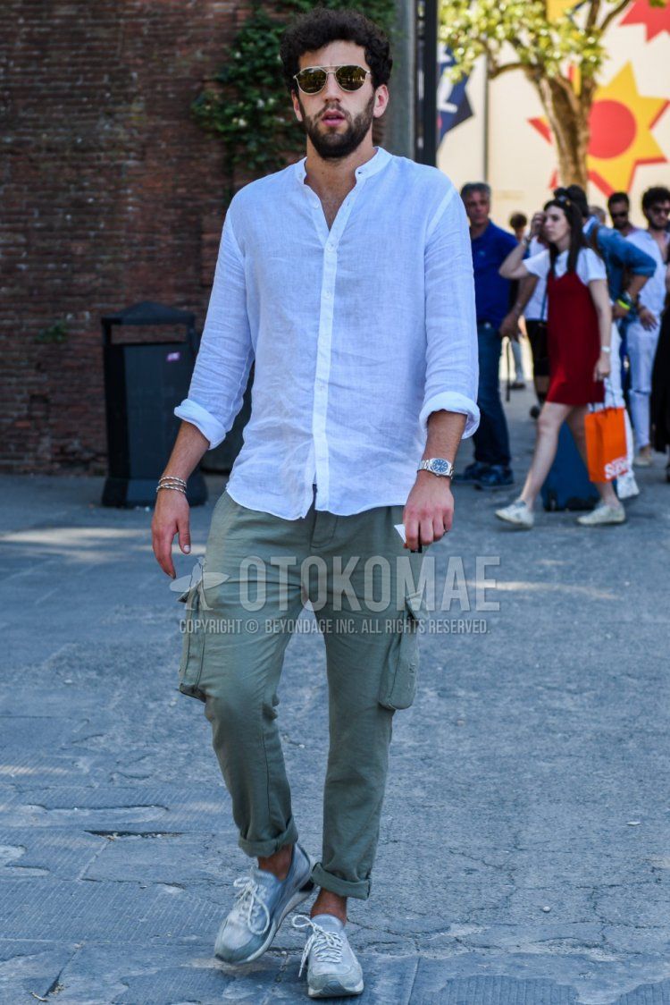 Men's spring, summer, and fall coordinate and outfit with gold and black plain sunglasses, linen plain white shirt, green plain cargo pants, and green low-cut sneakers.