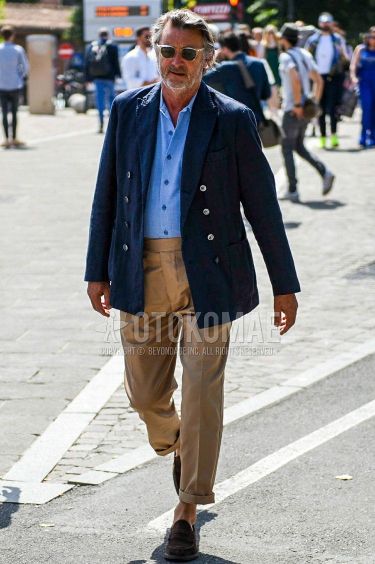 Men's spring, summer, and fall coordinate and outfit with clear solid color sunglasses, navy solid color tailored jacket, light blue solid color shirt, brown solid color beltless pants, and brown coin loafer leather shoes.