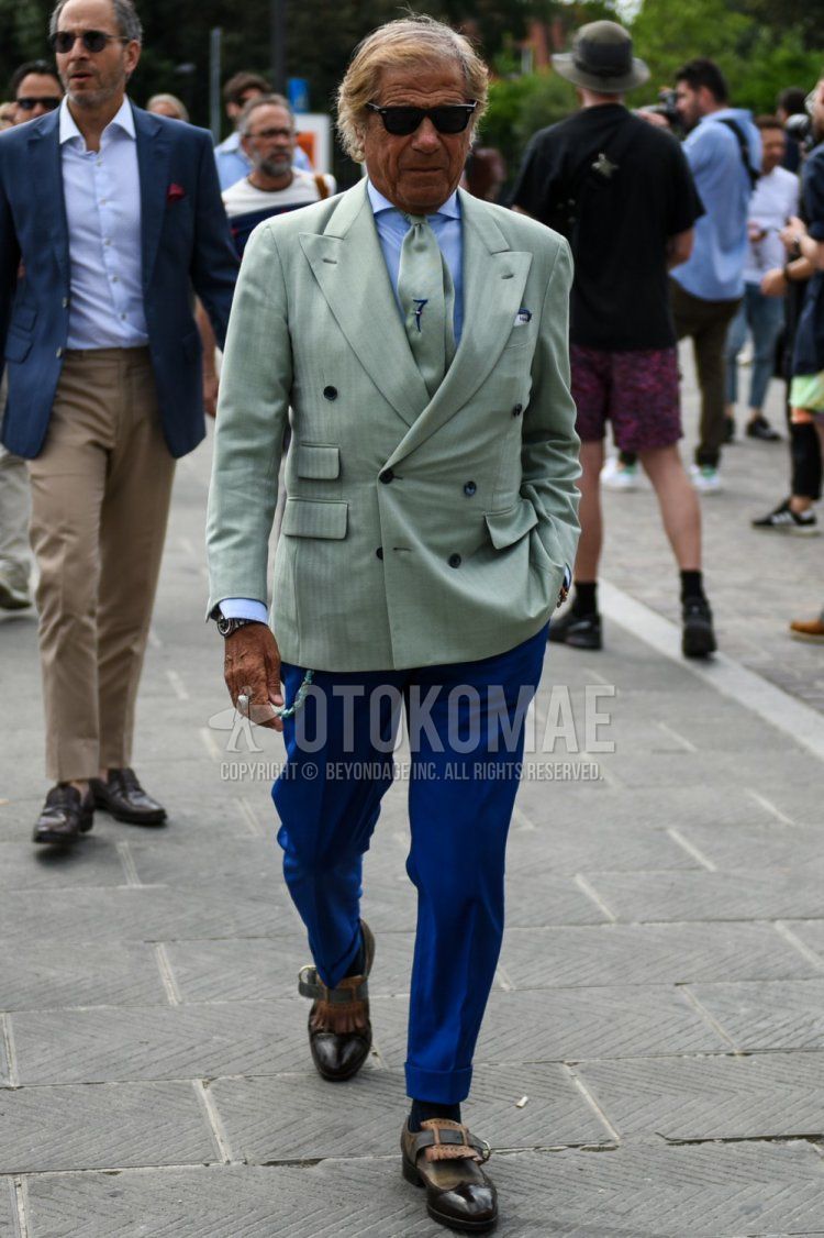Men's spring/summer/fall outfit with Wellington Ray-Ban solid black sunglasses, solid green tailored jacket, solid light blue shirt, solid blue slacks, solid navy socks, black/brown monkshoes leather shoes, and solid green tie.