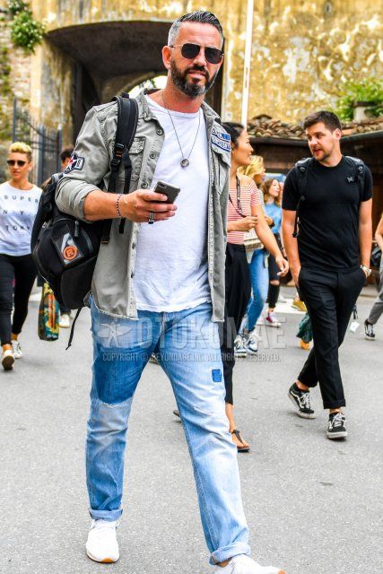 Men's spring/summer/autumn coordinate and outfit with solid color sunglasses, solid color green shirt jacket, solid color white t-shirt, solid color blue denim/jeans, and white low-cut sneakers.