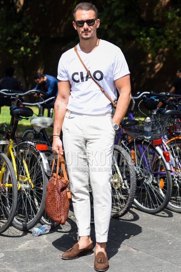 A summer men's coordinate and outfit with plain black sunglasses, plain white t-shirt, plain white slacks, brown tassel loafer leather shoes, and plain brown tote bag.