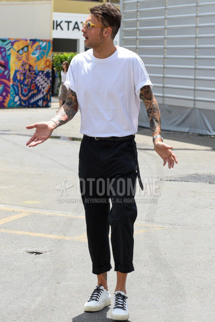 Summer men's coordinate and outfit with plain yellow glasses, plain white T-shirt, plain black leather belt, plain gray chinos and white low-cut sneakers.