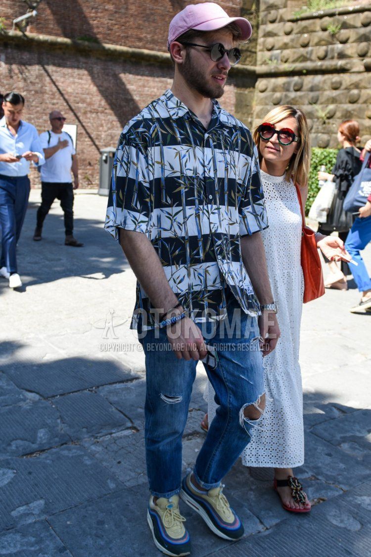 Summer men's coordinate and outfit with plain pink baseball cap, plain black sunglasses, white/navy striped shirt, plain blue damaged jeans, and Nike Air Max 97 multi-colored low-cut sneakers.
