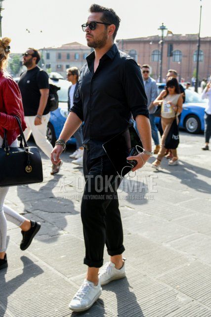 Men's spring and fall coordinate and outfit with plain sunglasses, plain black shirt, plain black cotton pants, and white low-cut sneakers.
