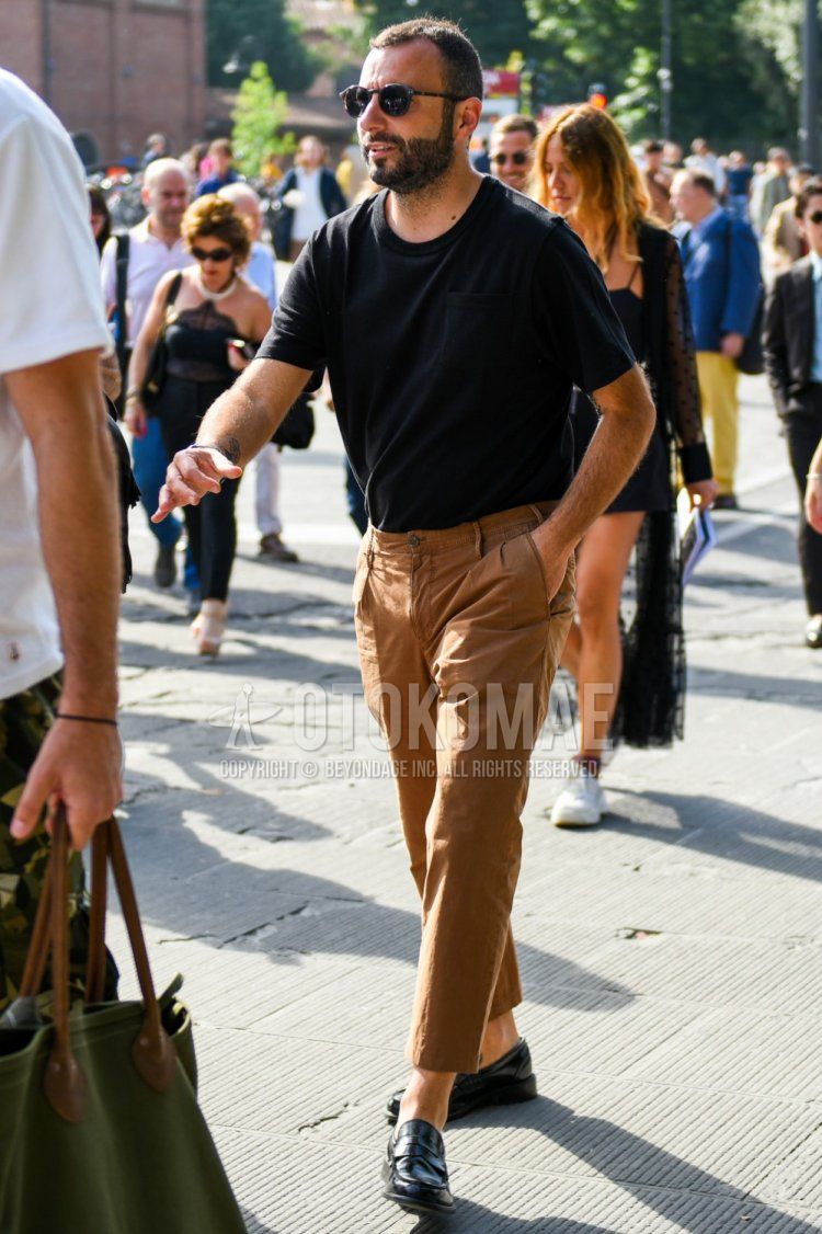 Men's summer coordinate and outfit with plain black sunglasses, plain black t-shirt, plain brown ankle pants, plain brown cotton pants, and black coin loafer leather shoes.