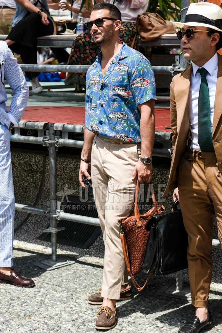 Wellington Ray Ban Wayfarer brown tortoiseshell sunglasses, blue top/inner shirt, solid beige ankle pants, solid chinos, solid pleated pants, brown moccasin/deck shoes leather shoes, solid brown briefcase/handbag Summer men's coordinate/outfit.