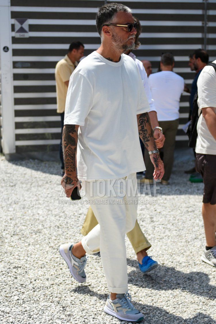 Men's summer coordinate and outfit with plain black sunglasses, plain white T-shirt, plain white wide pants, and light blue low-cut sneakers by Diadora.