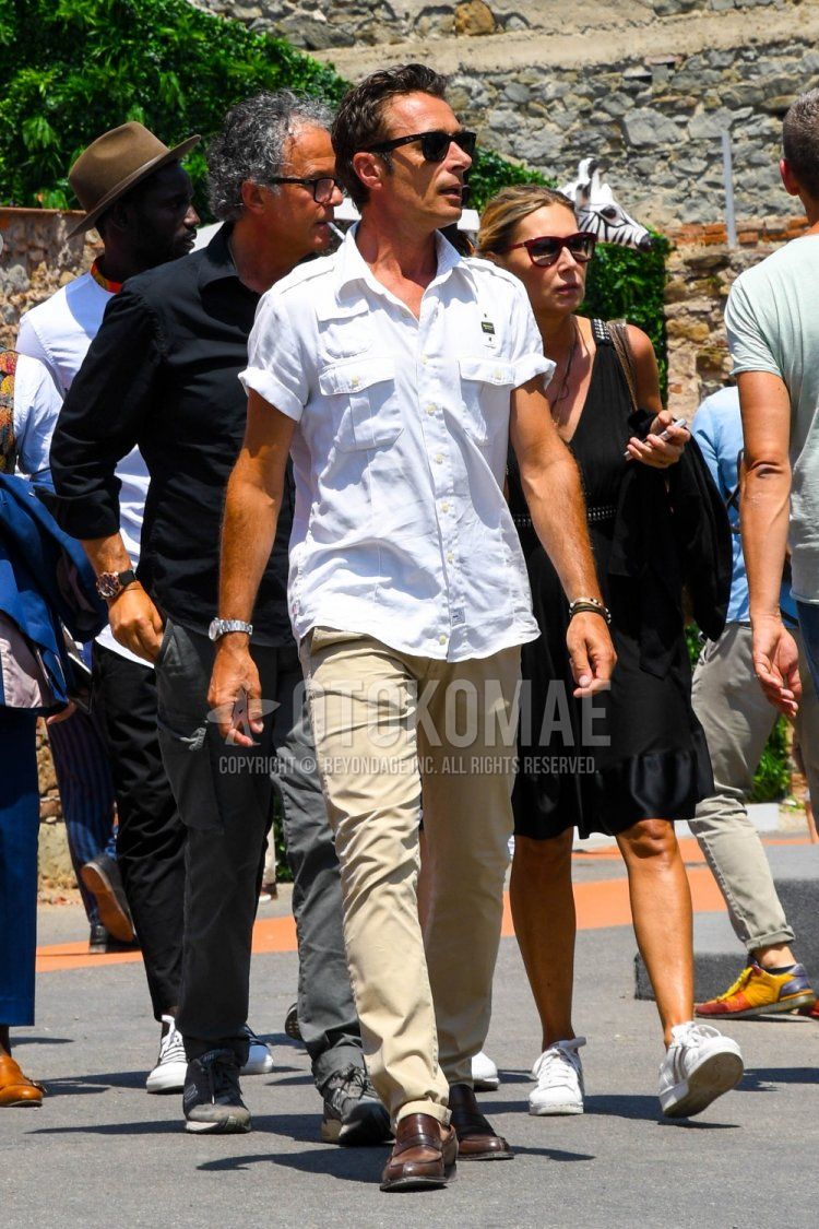 Men's spring and summer coordinate and outfit with Ray-Ban Wayfarer plain black sunglasses, plain white shirt, plain beige chinos and brown coin loafer leather shoes.