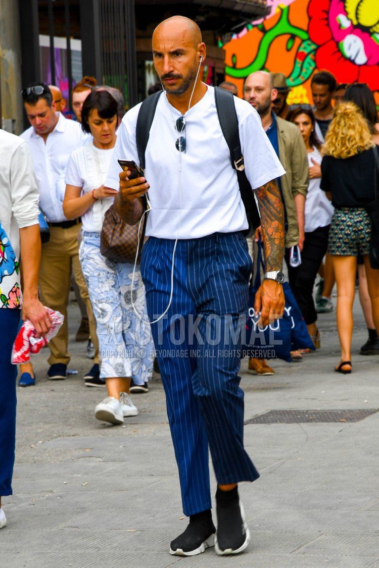 Men's spring/summer coordinate and outfit with plain black sunglasses, plain white t-shirt, navy striped slacks, black high-cut sneakers, and plain black backpack.