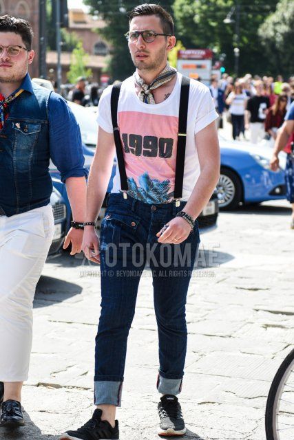 黒無地のメガネ、白グラフィックのTシャツ、黒無地のサスペンダー、ネイビー無地のデニム/ジーンズ、黒ローカットのスニーカーを合わせた夏のメンズコーデ・着こなし。